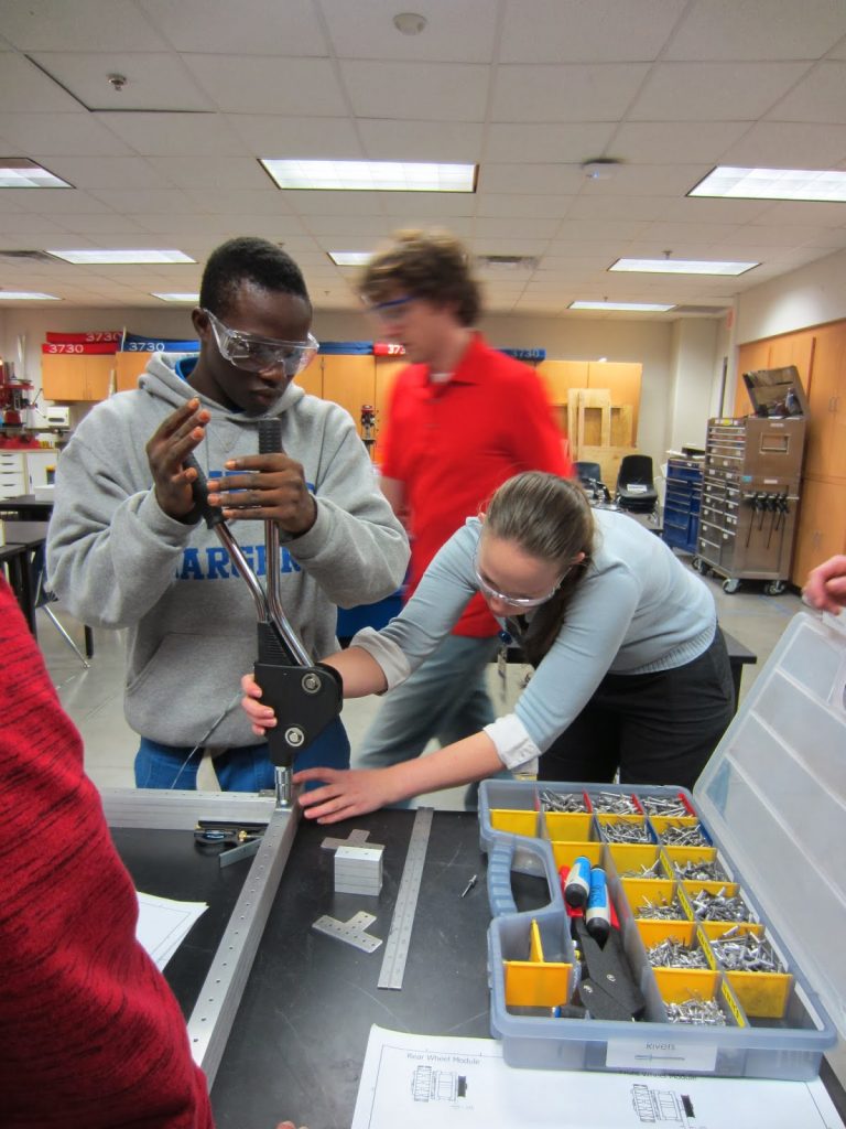 Taking a page from the RoboWrangler playbook - Mentor Rachel Moore shows student Curtis C. how to properly rivet